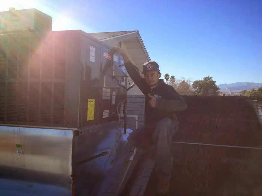 HVAC technician performing HVAC Inspection on a rooftop unit in Holmdel